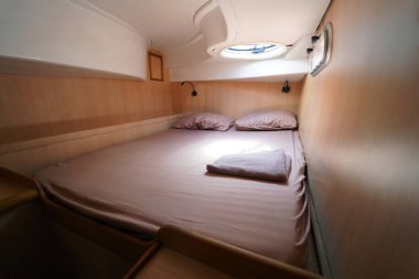 Yolculuk teknesinde rahat bir yatak ve üzerinde doğal ışık olan bir pencere..