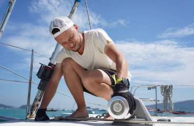 Beyaz şapkalı bir adam bir gezi teknesinde çalışıyor..