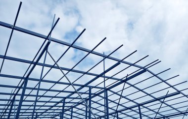 Arkasında bulutlu bir gökyüzü olan yapım aşamasındaki çatı.