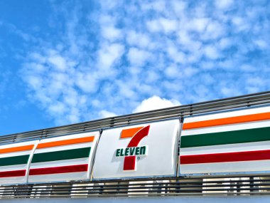 KUALA LUMPUR, MALAYSIA - 20 AĞUSTOS 2024: 7-eleven tabelasının arkasında güzel mavi gökyüzü olan market