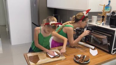 Anne ve kızı Noel 'de evde zencefilli ekmek pişiriyorlar..