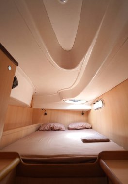 Yolculuk teknesinde rahat bir yatak ve üzerinde doğal ışık olan bir pencere..