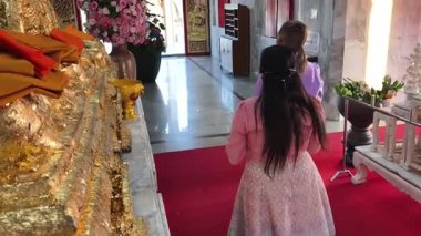 İki Taylandlı kadın Budist tapınağının huzurlu ortamında vakit geçirir..