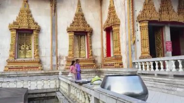 İki Taylandlı kadın Budist tapınağının huzurlu ortamında vakit geçirir..