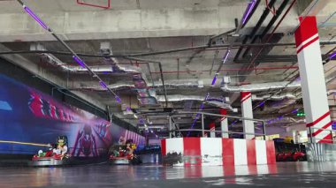 Bir grup kapalı pistte gokart yarıştırıyor motor seslerinin ve keskin virajların tadını çıkarıyor.