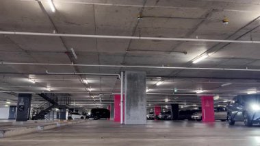 Modern bir elektrikli araç, çağdaş bir otoparkın içine park ediyor..