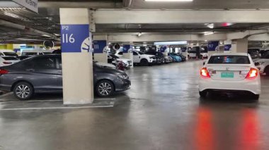 Düzenli olarak dizilmiş çeşitli arabaların sergilendiği modern bir otopark.