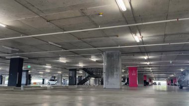 Modern bir elektrikli araç, çağdaş bir otoparkın içine park ediyor..