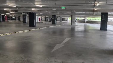 Geniş ve modern bir otopark. Temiz hatları ve bol ışıklandırması var. 