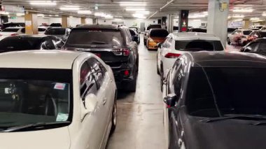 Birbirine yakın arabalarla dolu hareketli bir otopark..
