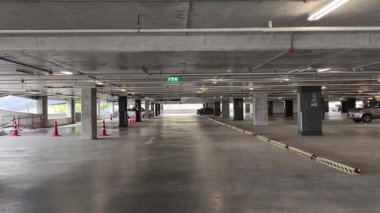 Geniş ve modern bir otopark. Temiz hatları ve bol ışıklandırması var. 