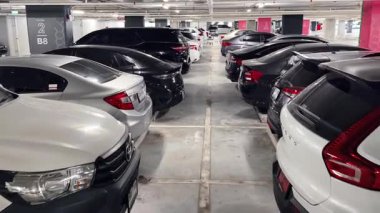 Birbirine yakın arabalarla dolu hareketli bir otopark..