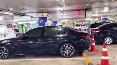 Birbirine yakın arabalarla dolu hareketli bir otopark..