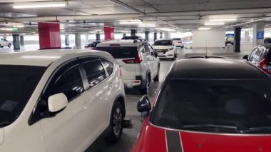 Birbirine yakın arabalarla dolu hareketli bir otopark..