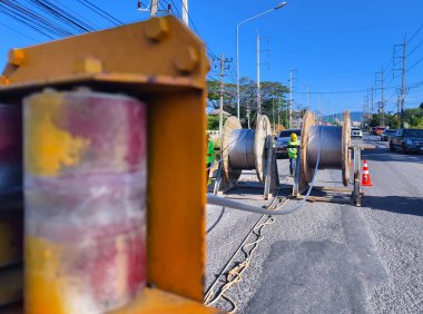 Yol boyunca yeni direklere yüksek gerilimli elektrik kabloları kurulumu.