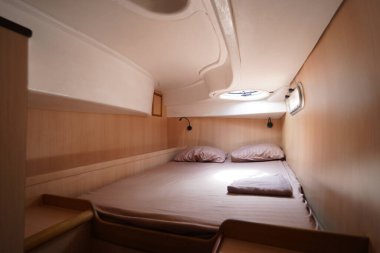 Yolculuk teknesinde rahat bir yatak ve üzerinde doğal ışık olan bir pencere..