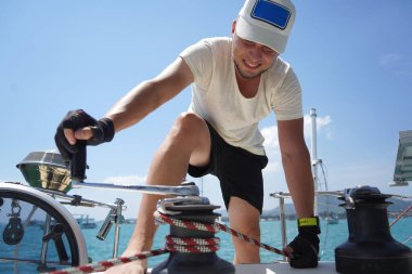 Beyaz şapkalı bir adam bir gezi teknesinde çalışıyor..