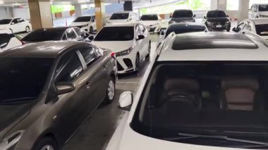 Birbirine yakın arabalarla dolu hareketli bir otopark..