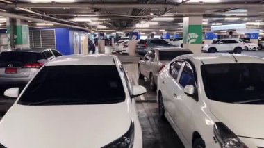 Birbirine yakın arabalarla dolu hareketli bir otopark..