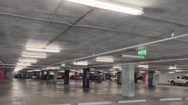 Geniş ve modern bir otopark. Temiz hatları ve bol ışıklandırması var. 