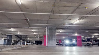 Modern bir elektrikli araç, çağdaş bir otoparkın içine park ediyor..