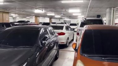 Birbirine yakın arabalarla dolu hareketli bir otopark..
