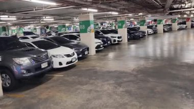 Düzenli olarak dizilmiş çeşitli arabaların sergilendiği modern bir otopark.