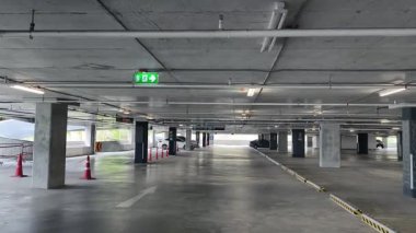 Geniş ve modern bir otopark. Temiz hatları ve bol ışıklandırması var. 