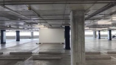 Geniş ve modern bir otopark. Temiz hatları ve bol ışıklandırması var. 