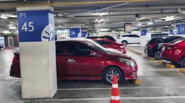 Birbirine yakın arabalarla dolu hareketli bir otopark..