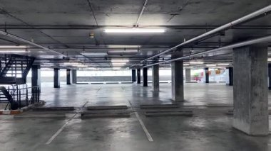 Geniş ve modern bir otopark. Temiz hatları ve bol ışıklandırması var. 