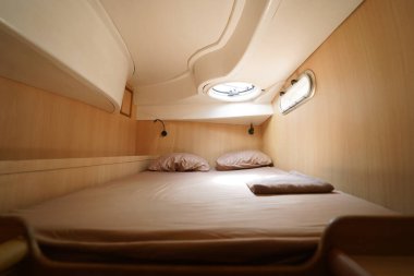 Yolculuk teknesinde rahat bir yatak ve üzerinde doğal ışık olan bir pencere..