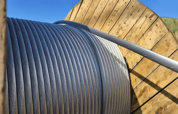 Yolun üzerinde büyük bir tahta makara yüksek voltajlı elektrik teli var..