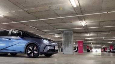 Modern bir elektrikli araç, çağdaş bir otoparkın içine park ediyor..