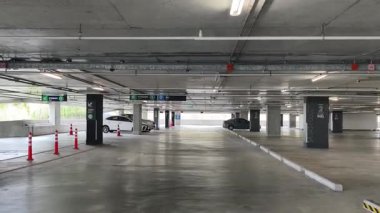 Geniş ve modern bir otopark. Temiz hatları ve bol ışıklandırması var. 
