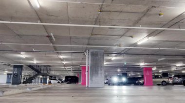 Modern bir elektrikli araç, çağdaş bir otoparkın içine park ediyor..