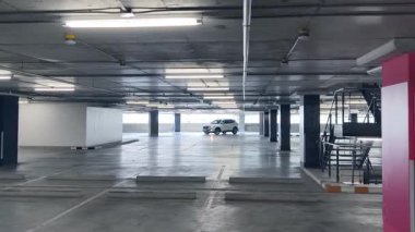 Geniş ve modern bir otopark. Temiz hatları ve bol ışıklandırması var. 