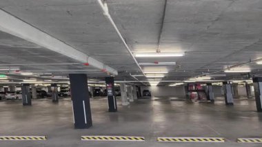 Geniş ve modern bir otopark. Temiz hatları ve bol ışıklandırması var. 