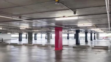 Geniş ve modern bir otopark. Temiz hatları ve bol ışıklandırması var. 