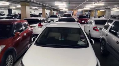 Birbirine yakın arabalarla dolu hareketli bir otopark..