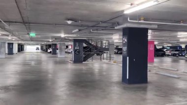 Geniş ve modern bir otopark. Temiz hatları ve bol ışıklandırması var. 