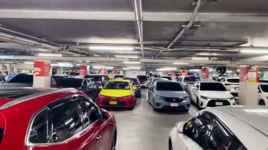 Birbirine yakın arabalarla dolu hareketli bir otopark..