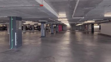 Geniş ve modern bir otopark. Temiz hatları ve bol ışıklandırması var. 