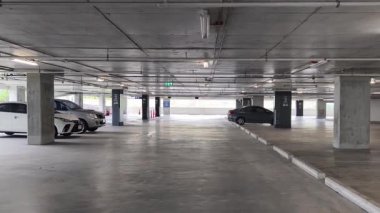 Geniş ve modern bir otopark. Temiz hatları ve bol ışıklandırması var. 