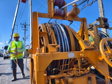 Yol boyunca yeni direklere yüksek gerilimli elektrik kabloları kurulumu.