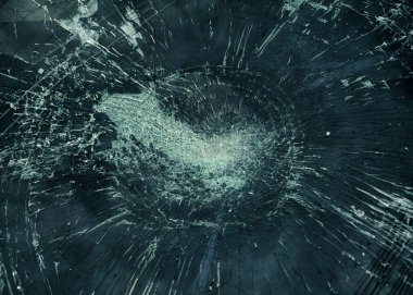 Parlak kırmızı bir arabanın ön camı kırılmış ve kırılmış. Bu da cam yüzeyindeki hasarı gösteriyor..