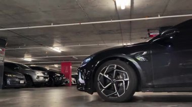 Modern bir elektrikli araç, çağdaş bir otoparkın içine park ediyor..