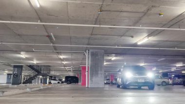 Modern bir elektrikli araç, çağdaş bir otoparkın içine park ediyor..