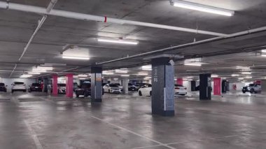 Geniş ve modern bir otopark. Temiz hatları ve bol ışıklandırması var. 
