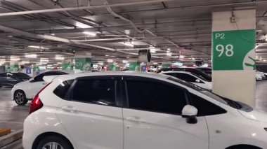 Birbirine yakın arabalarla dolu hareketli bir otopark..